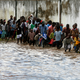 People walk through a flooded area in Dar es Salaam.